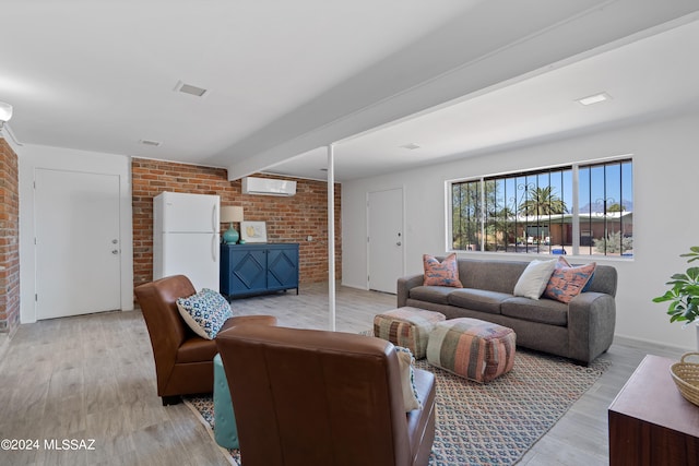 living room featuring an AC wall unit, beamed ceiling, light hardwood / wood-style floors, and brick wall