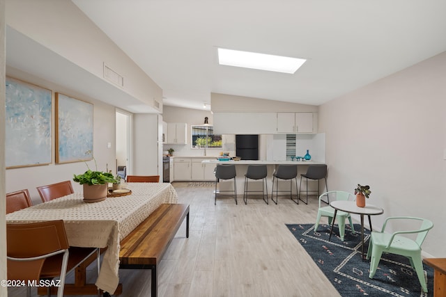 dining space featuring light hardwood / wood-style flooring and vaulted ceiling