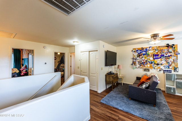 living room featuring dark hardwood / wood-style floors and ceiling fan