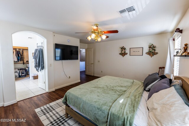 bedroom featuring wood-type flooring, a closet, a spacious closet, and ceiling fan