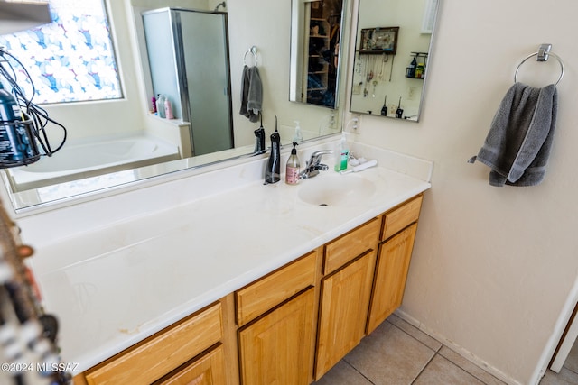 bathroom featuring tile patterned flooring, vanity, and separate shower and tub