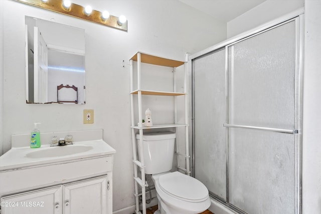 bathroom featuring vanity, toilet, and an enclosed shower