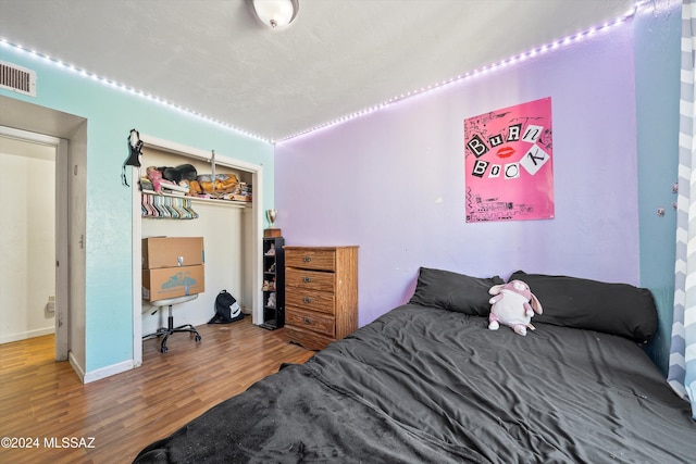 bedroom with wood-type flooring and a closet