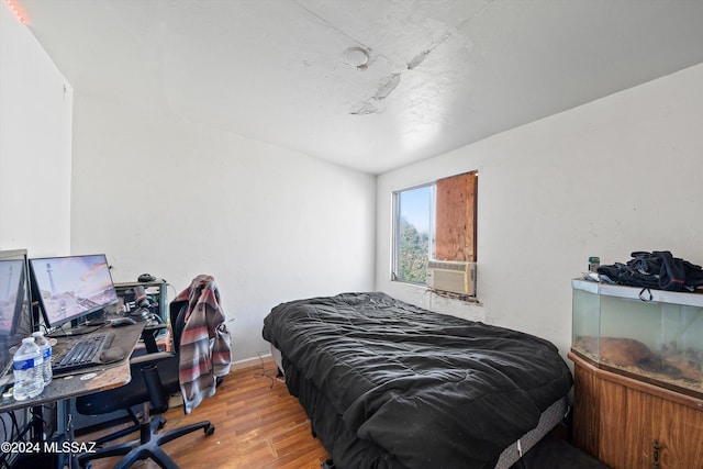 bedroom featuring hardwood / wood-style floors and cooling unit