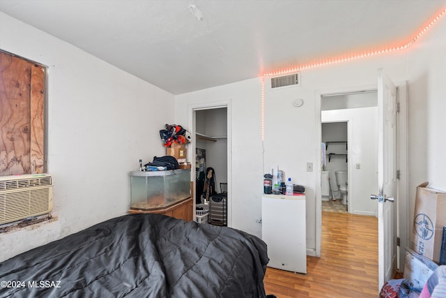 bedroom featuring wood-type flooring and a wall mounted AC