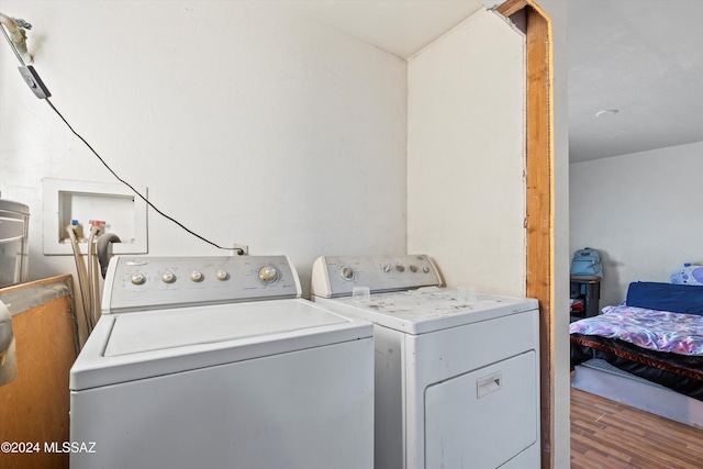 washroom with washing machine and dryer and dark wood-type flooring