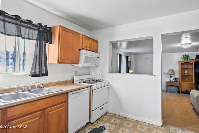 kitchen featuring hardwood / wood-style floors, white appliances, and sink