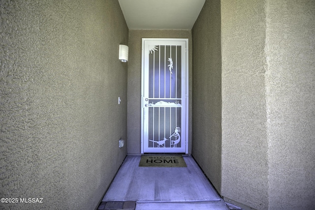 view of exterior entry with stucco siding