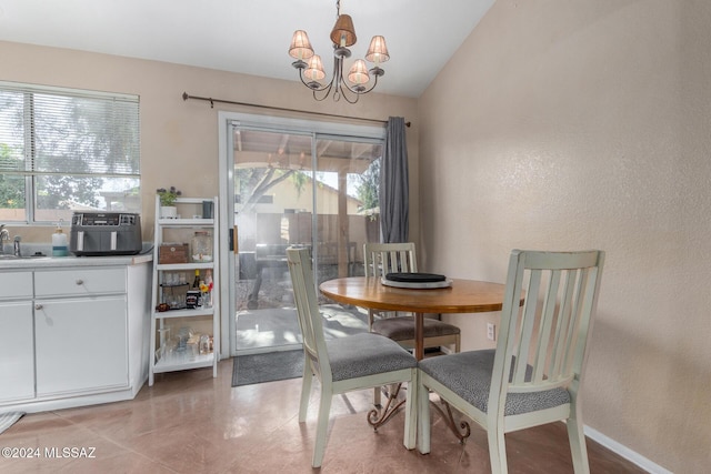 dining room featuring a chandelier, sink, a healthy amount of sunlight, and vaulted ceiling