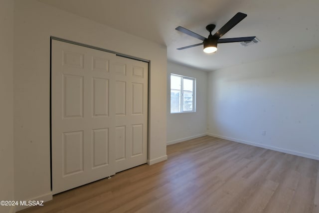 unfurnished bedroom featuring a closet, light hardwood / wood-style flooring, and ceiling fan