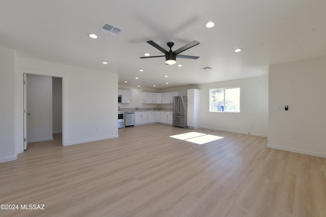 unfurnished living room featuring ceiling fan and light hardwood / wood-style floors