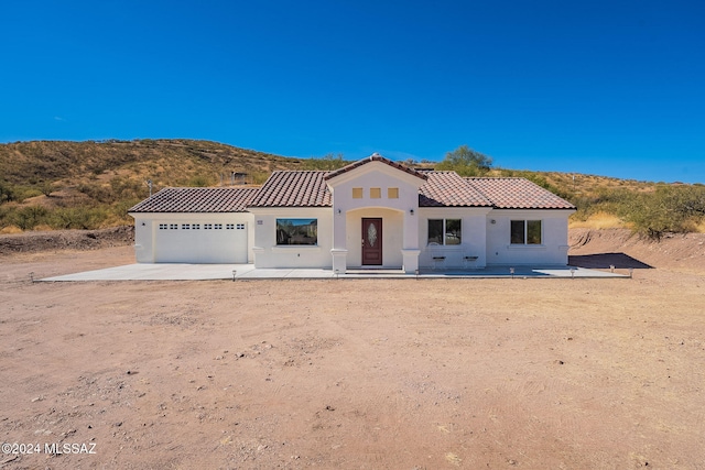 mediterranean / spanish house with a mountain view, a patio, and a garage