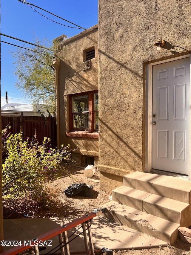 view of exterior entry featuring fence