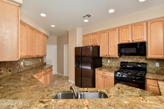 kitchen featuring light brown cabinetry, sink, and black appliances