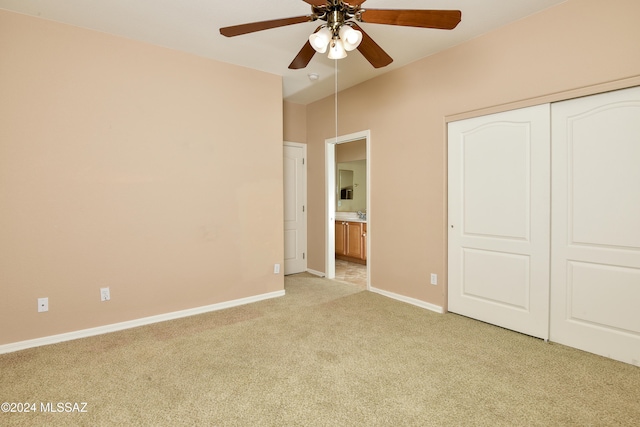 unfurnished bedroom with light carpet, a closet, and ceiling fan