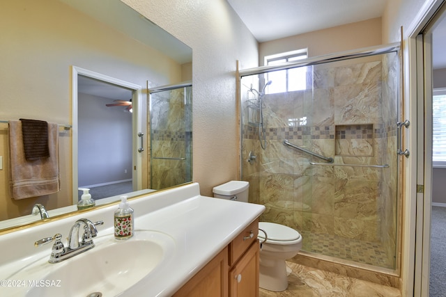 bathroom featuring toilet, vanity, and walk in shower