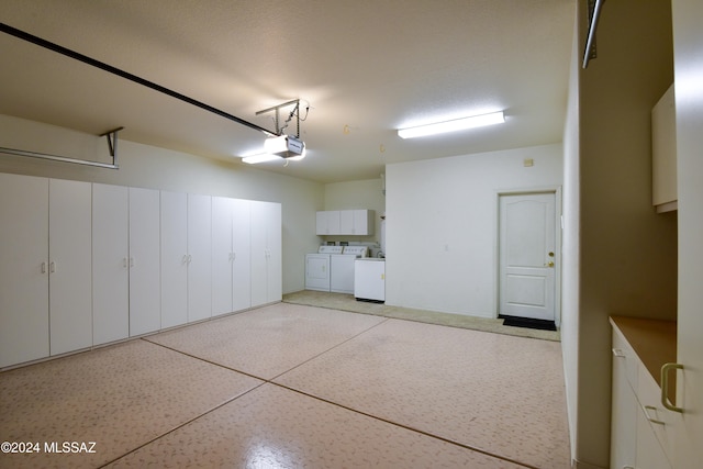 garage featuring washing machine and clothes dryer and a garage door opener