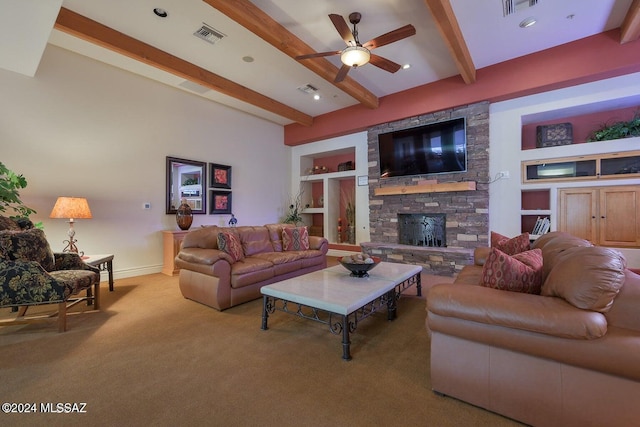 carpeted living room featuring built in shelves, ceiling fan, a stone fireplace, and beamed ceiling