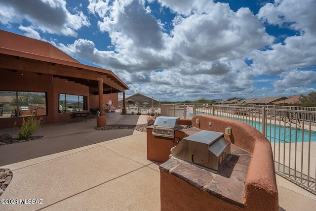 view of patio featuring area for grilling, grilling area, and a community pool