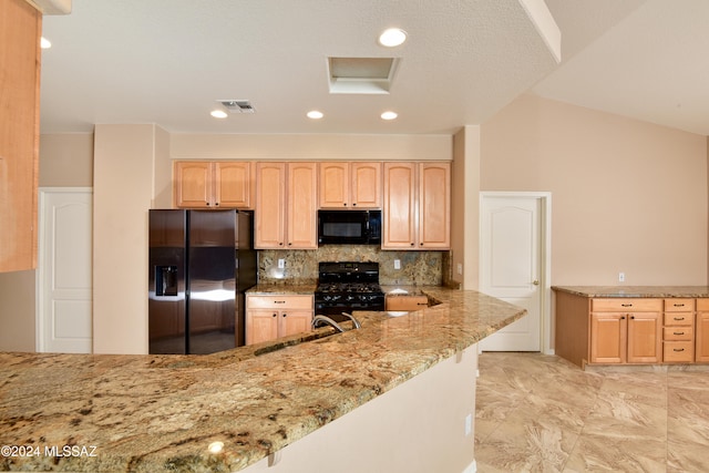 kitchen featuring light brown cabinetry, sink, light stone counters, and black appliances