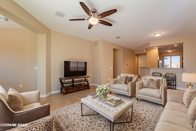 living room with ceiling fan, light tile patterned floors, visible vents, and baseboards