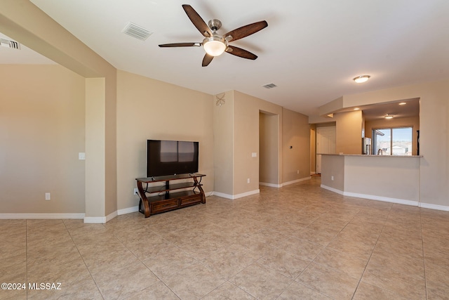 living area with baseboards, visible vents, and ceiling fan