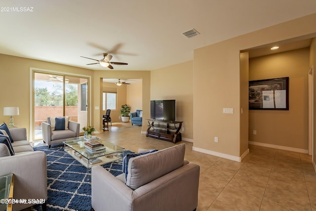 living room featuring light tile patterned floors, visible vents, baseboards, and ceiling fan