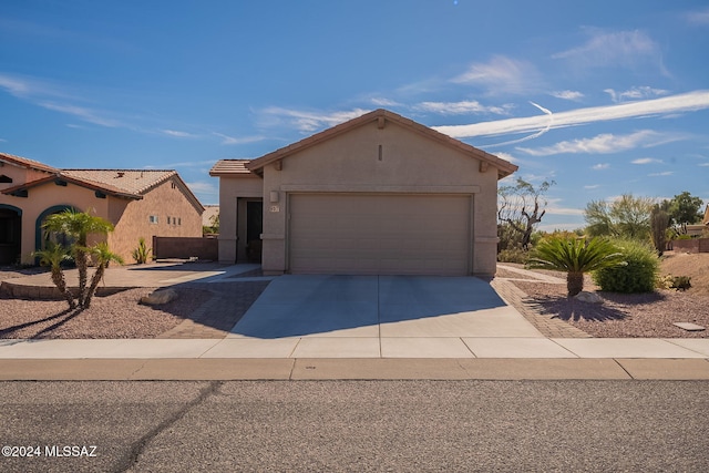 view of front of property with an attached garage, a tile roof, concrete driveway, and stucco siding