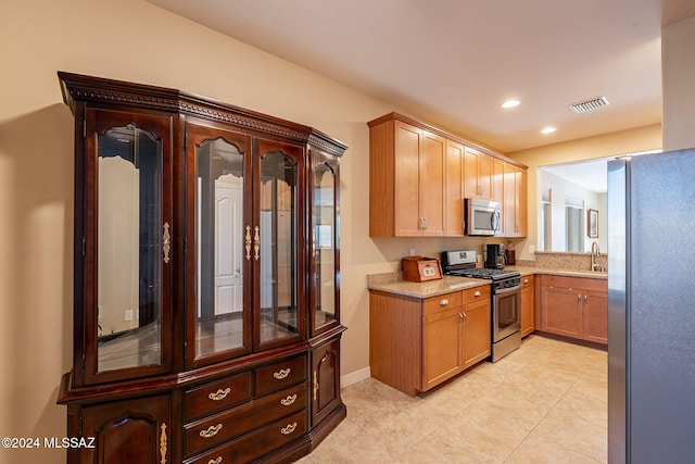 kitchen featuring light tile patterned floors, visible vents, appliances with stainless steel finishes, light stone countertops, and recessed lighting