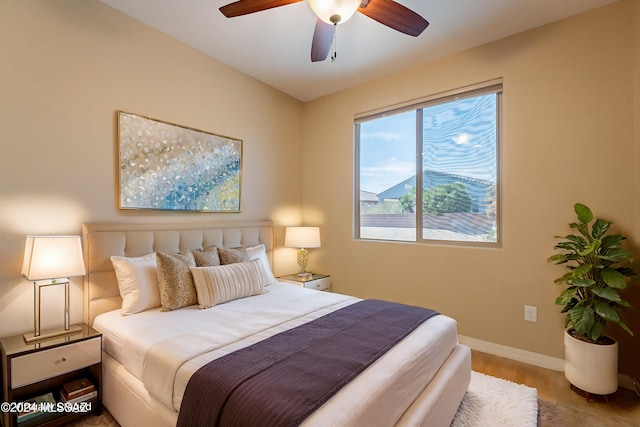 bedroom featuring a ceiling fan, baseboards, and wood finished floors