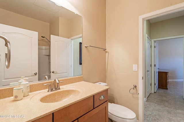 bathroom with toilet, baseboards, vanity, and tile patterned floors