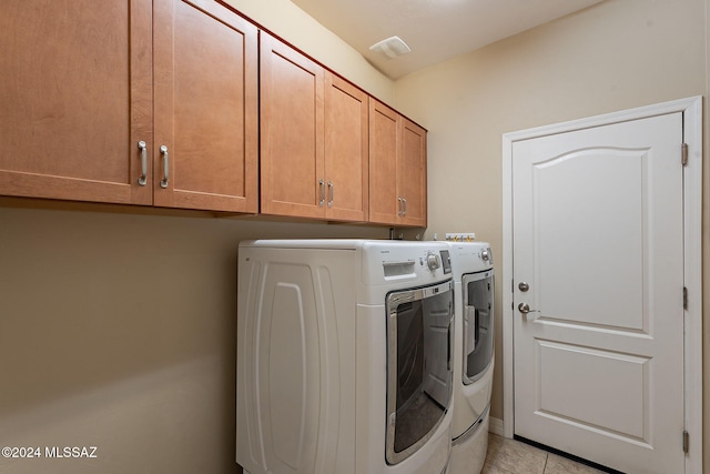 laundry area featuring cabinet space, washer and clothes dryer, and light tile patterned flooring