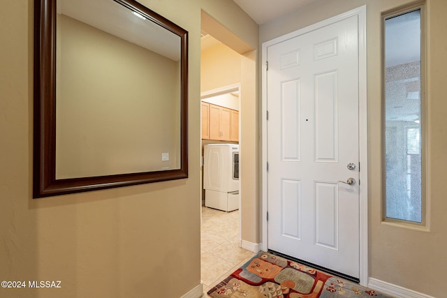 corridor with washer / dryer, baseboards, and light tile patterned flooring