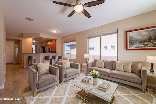 living room featuring a ceiling fan, visible vents, and baseboards