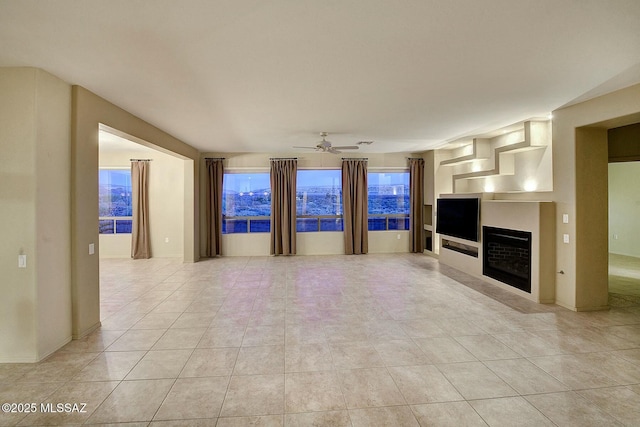 unfurnished living room featuring ceiling fan and light tile patterned floors