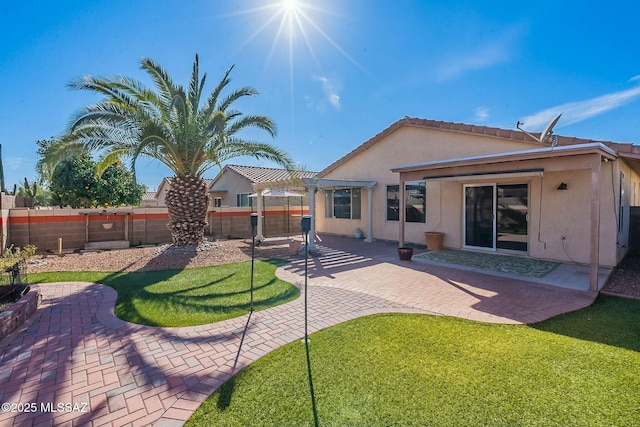 rear view of house with a yard, a patio, stucco siding, a pergola, and a fenced backyard