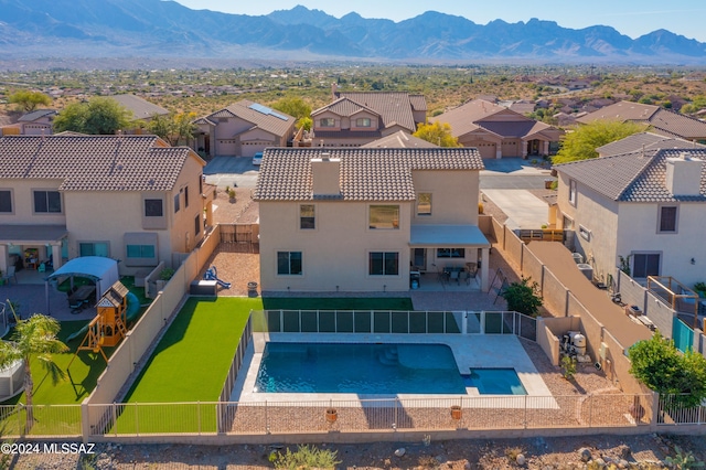 view of swimming pool featuring a patio, a residential view, a fenced backyard, and a mountain view