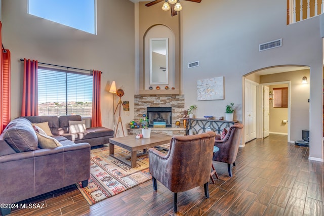 living room with wood tiled floor, a fireplace, visible vents, and arched walkways