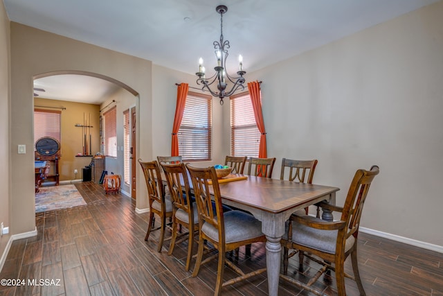 dining room featuring arched walkways, baseboards, a chandelier, and wood tiled floor