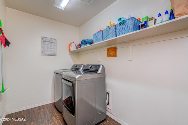 clothes washing area featuring laundry area, dark wood-style flooring, visible vents, baseboards, and washer and clothes dryer