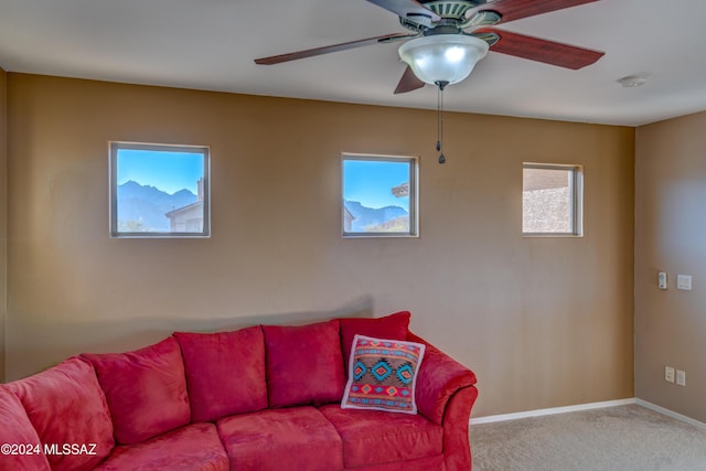 carpeted living room featuring ceiling fan and baseboards