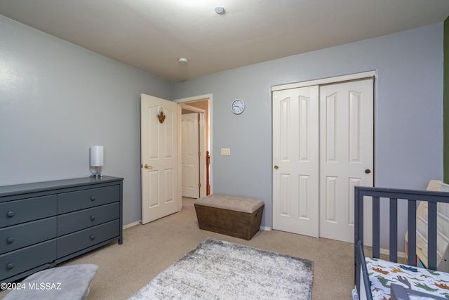 carpeted bedroom featuring a closet and baseboards