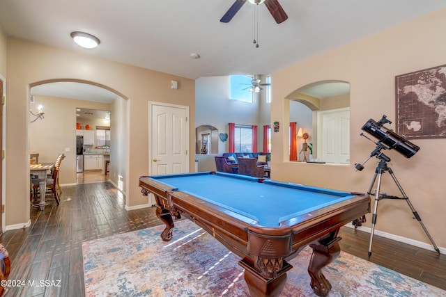 rec room with arched walkways, wood finish floors, a ceiling fan, and baseboards