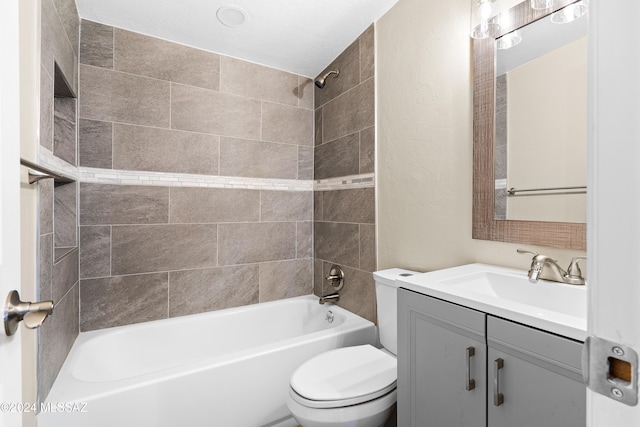 full bathroom featuring tiled shower / bath, vanity, and toilet