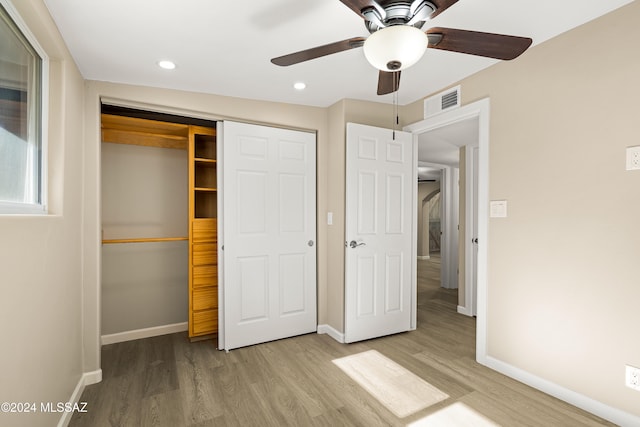 unfurnished bedroom featuring ceiling fan, a closet, and light hardwood / wood-style flooring