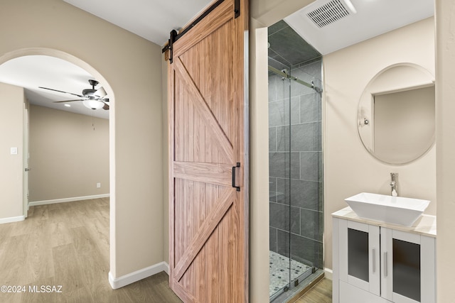 bathroom featuring vanity, hardwood / wood-style flooring, ceiling fan, and a shower with shower door