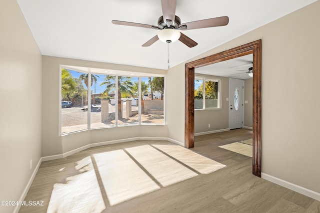 empty room with hardwood / wood-style floors, vaulted ceiling, and ceiling fan