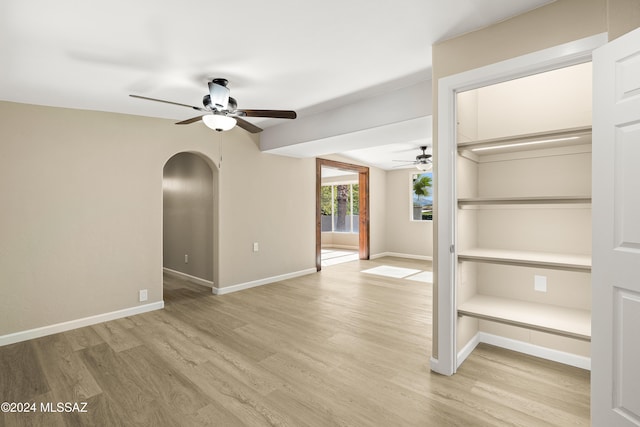 empty room with ceiling fan and light hardwood / wood-style floors