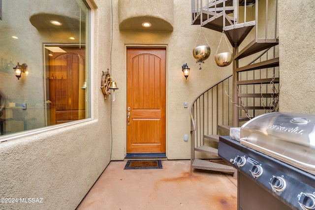 view of front facade featuring a pergola, a tile roof, stucco siding, a gate, and a balcony