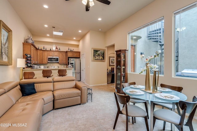living area featuring light tile patterned floors, baseboards, a ceiling fan, and recessed lighting